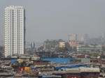 La ville en raccourci: les toits du bidonville de Dharavi au premier plan, des immeubles vétustes et une tour récente au deuxième plan, une infrastructure toute neuve, le "Sea Link", au fond (1/22)